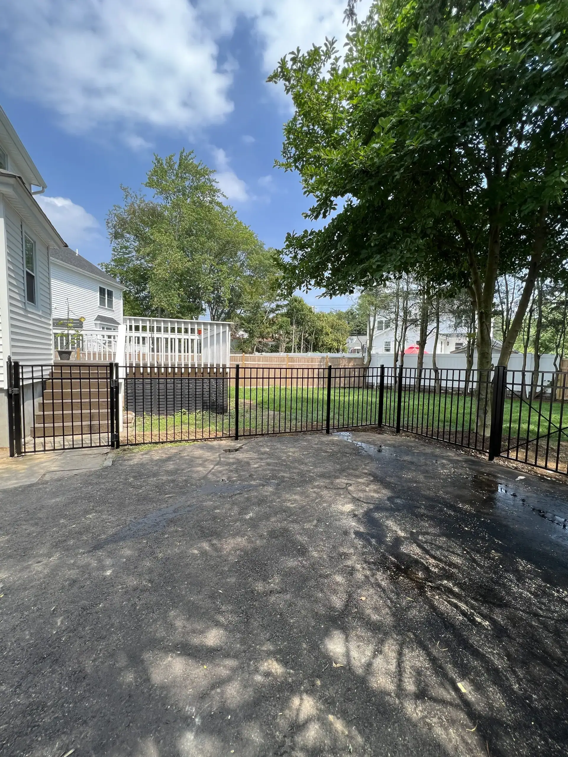 Black aluminum fence and gate across a driveway