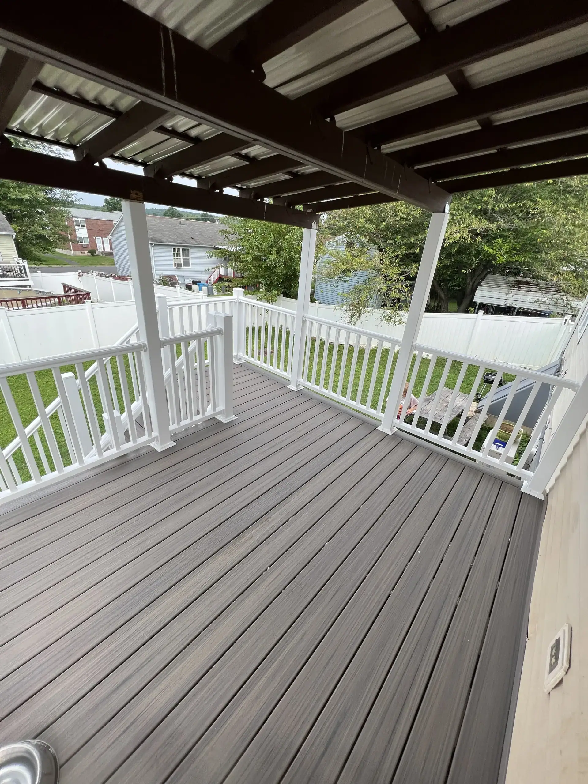Covered composite deck with white vinyl railings