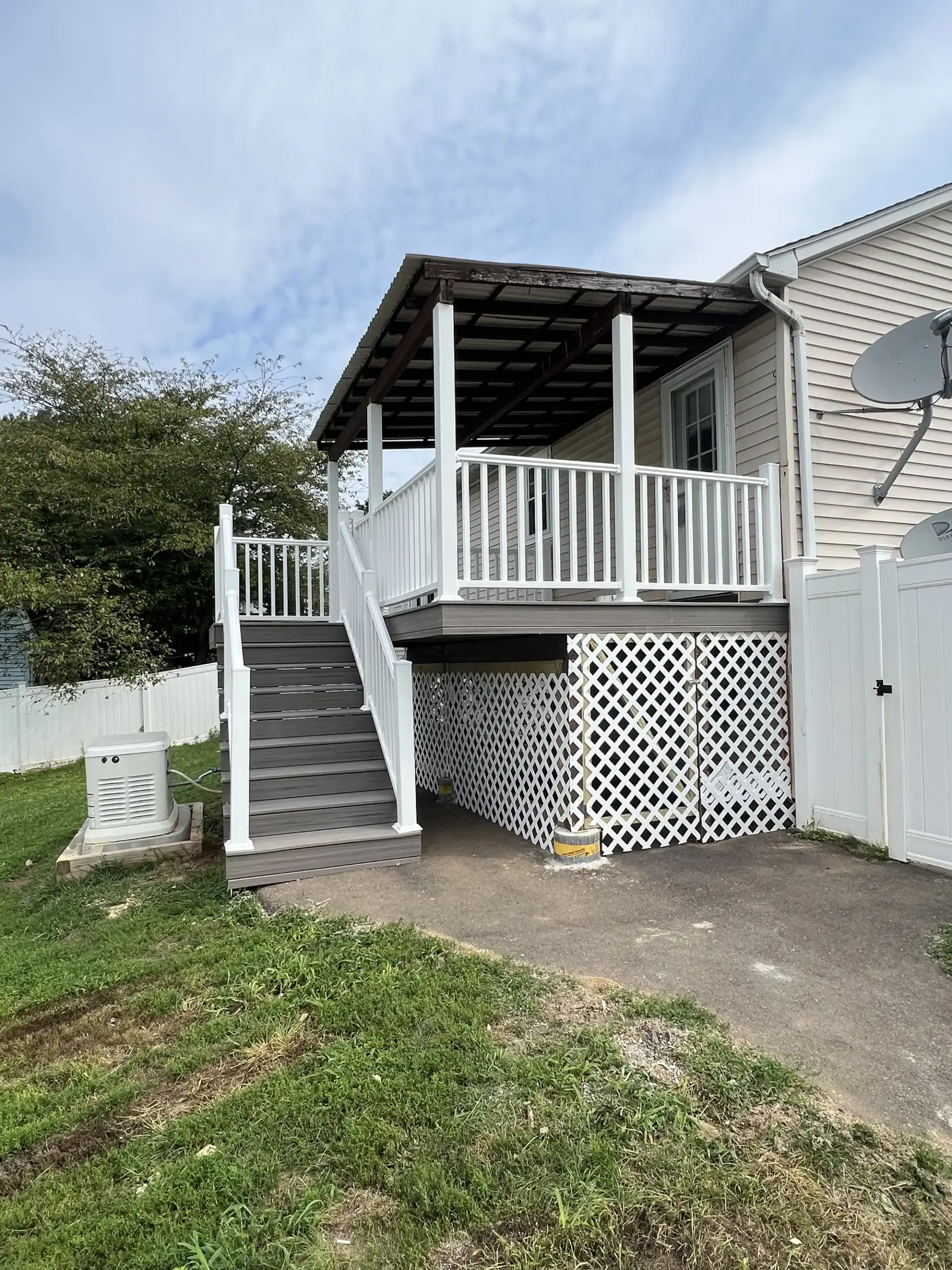 Covered raised deck with stairs, vinyl railings and lattice skirting