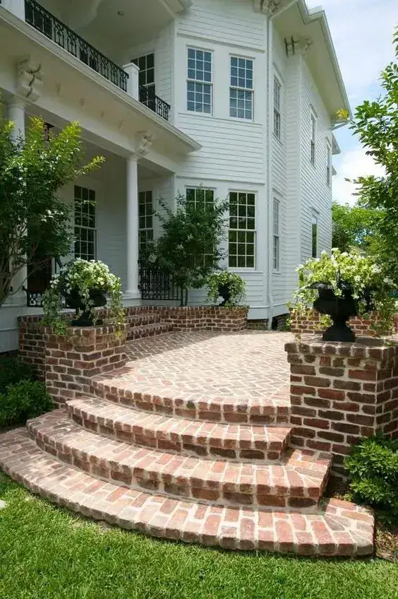 Curved brick front steps flanked by brick planters