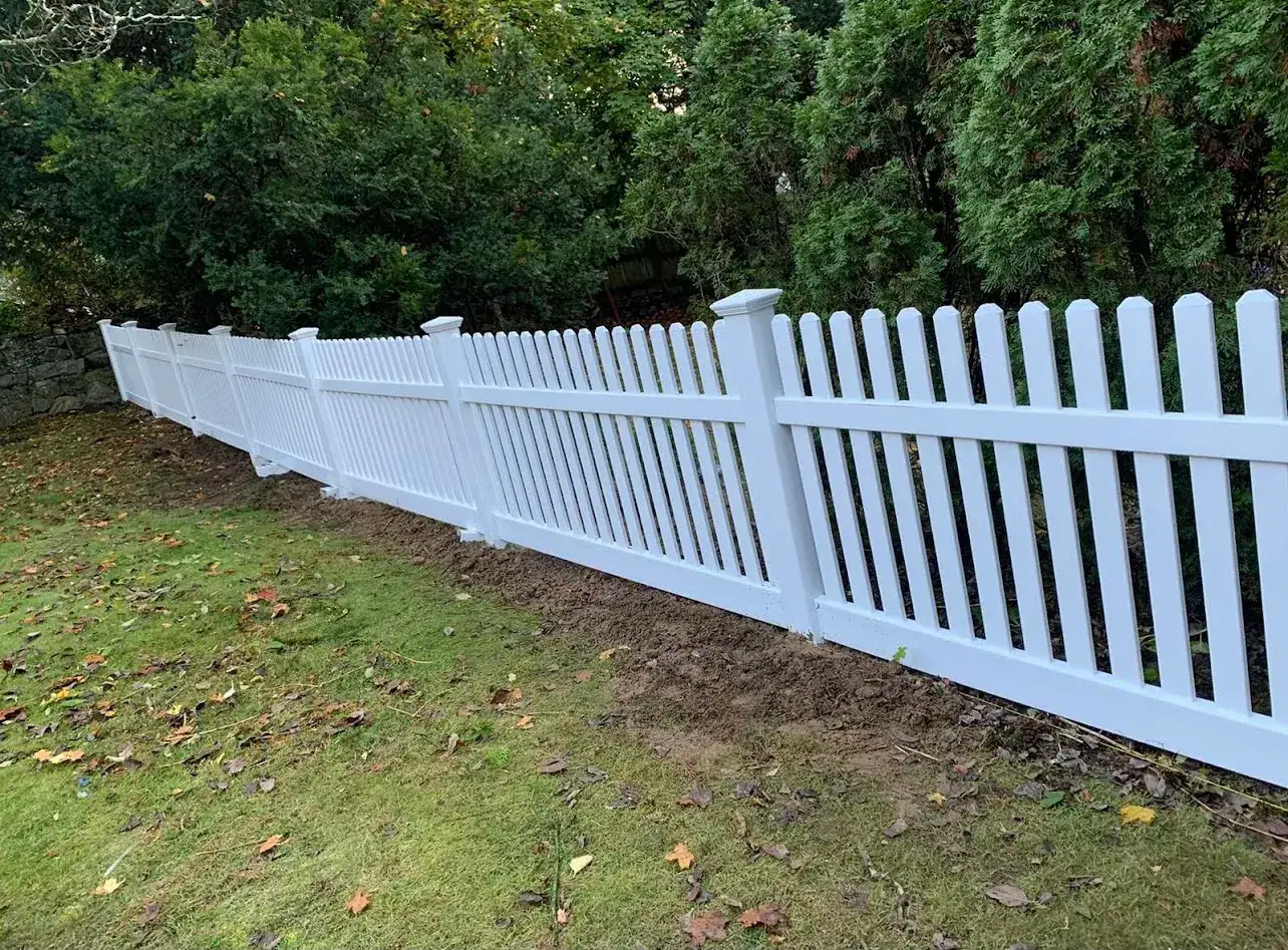 White vinyl picket fence along a side yard