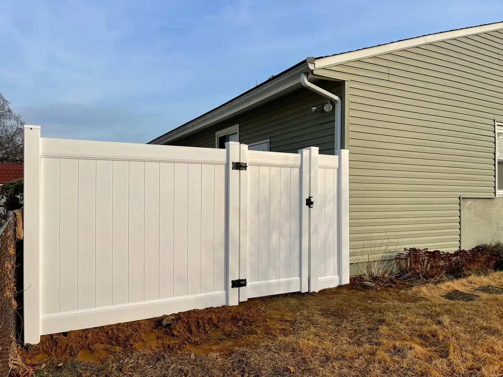 White vinyl privacy fence with a walk gate